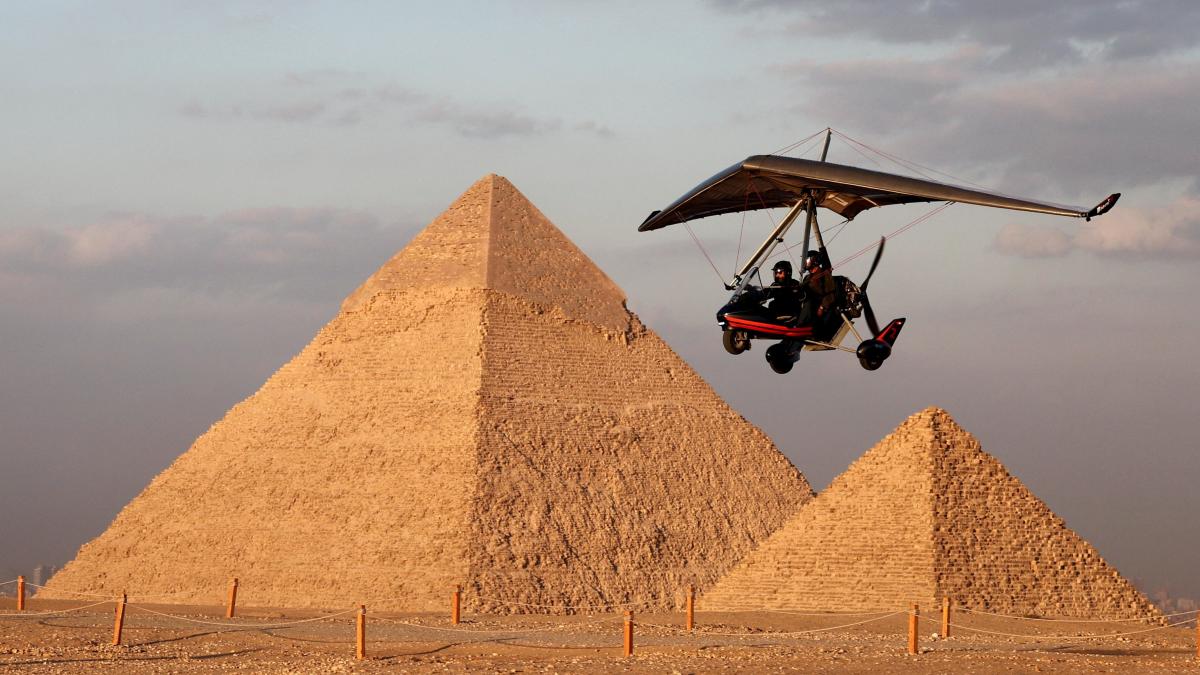 Arte frente a las pirámides de Guiza en Egipto, luces navideñas y más imágenes del día